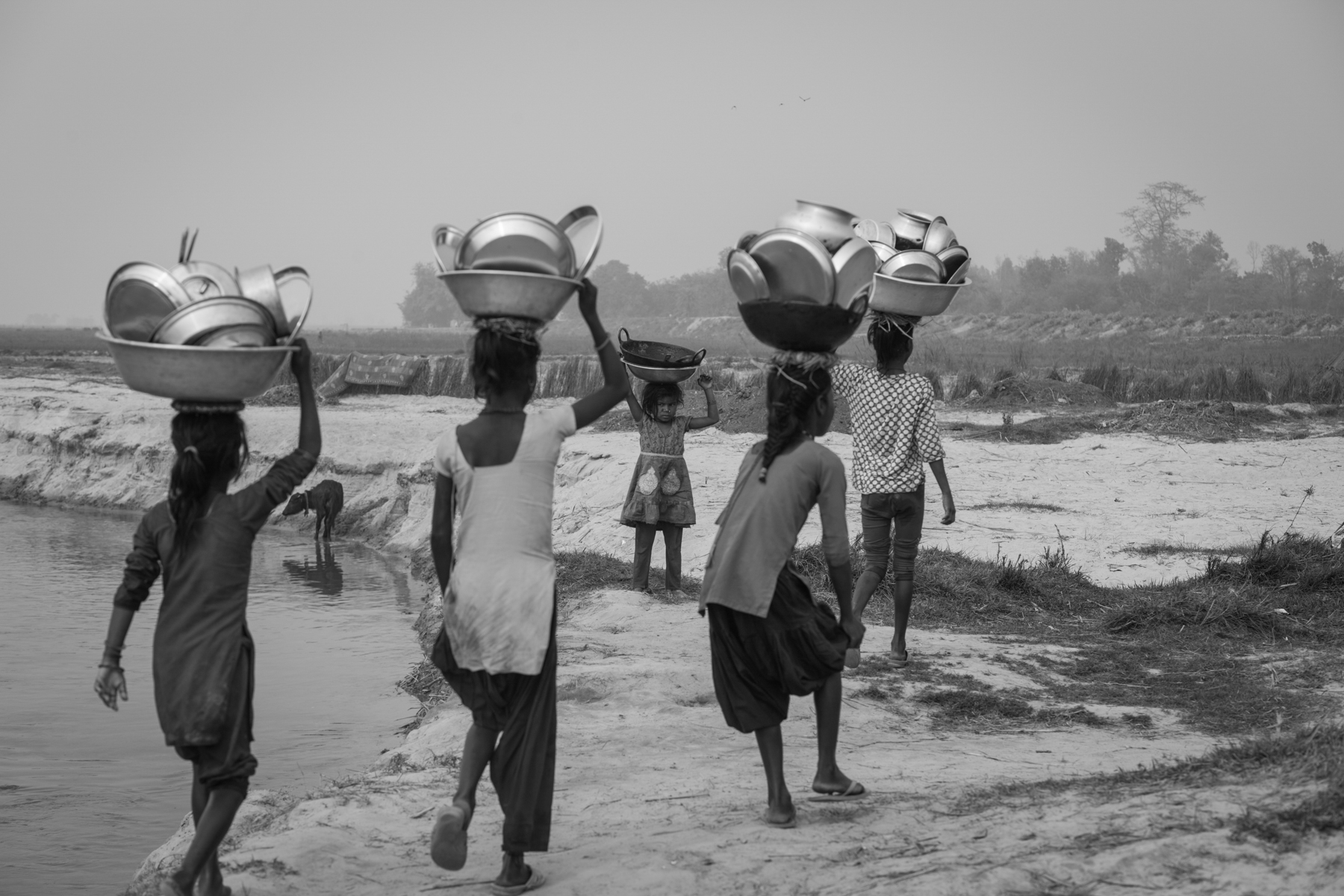 Young girls return home after cleaning utensils in the Kamala River. 19 Feburary 2020, Chikana, Siraha, Nepal. 