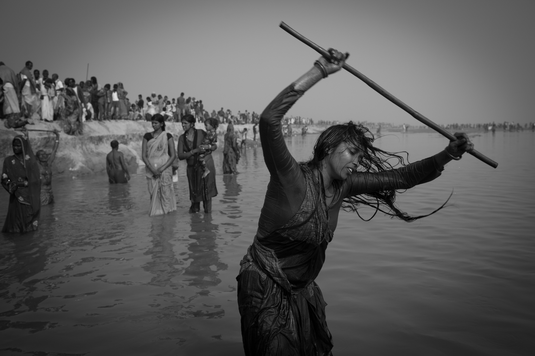Urmila Yadav with her protective stick after taking a bath in the Kamala River. Dhamis claim that after this ritual she will be freed
from ghosts and witches. 12 November 2019, Dhanusha, Nepal.