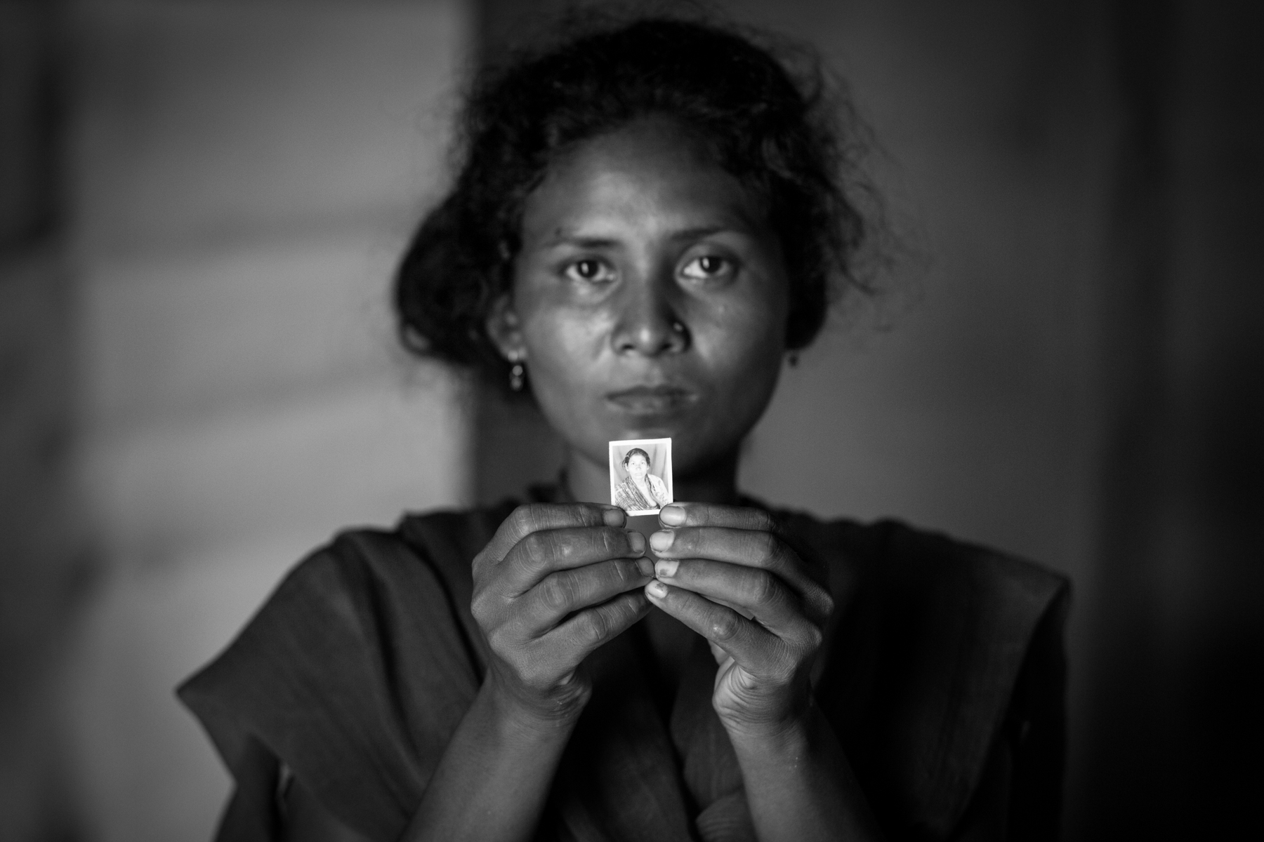 Sunkesi Chaudhary shows a photo of her mother, Parvati Devi Chaudhary, who was beaten to death at midnight on 16 August 2013. She was 45 years old. 24 August 2013, Supauli, Parsa, Nepal.